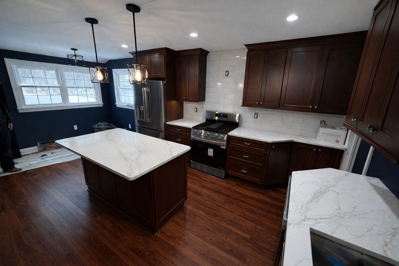 Full kitchen renovation — dark custom cabinetry and marble countertops