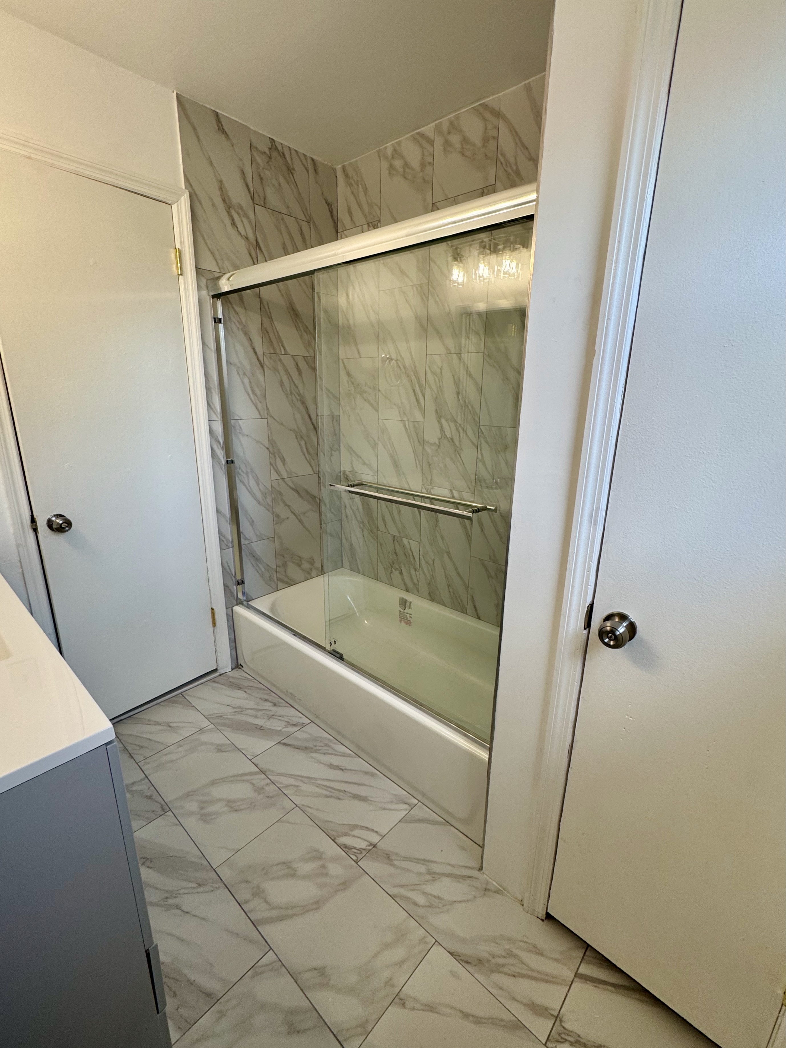 Tub and shower remodel — marble tile walls and glass sliding door
