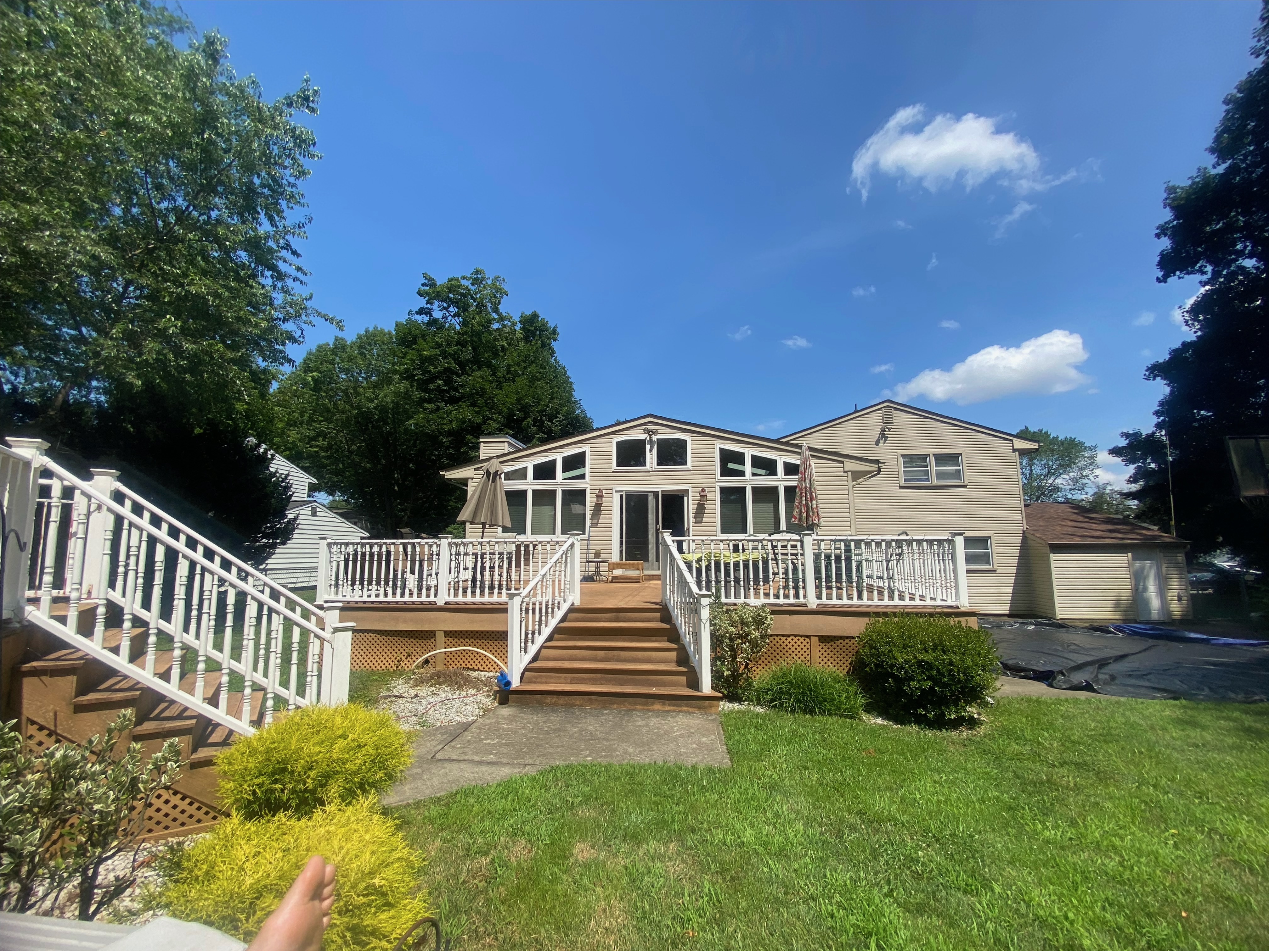 Home addition and exterior — multi-level deck with white railings and landscaping